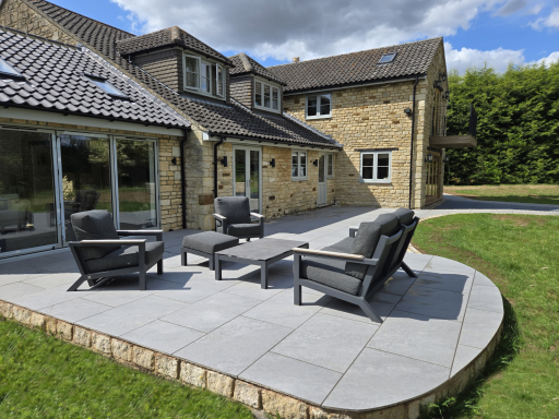 A porcelain seating area with modern patio furniture infront of bifold doors