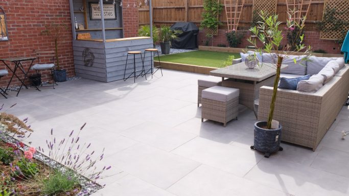 A grey porcelain patio with bar and seating area