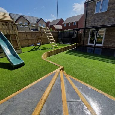 Garden featuring artificial grass, porcelain steps and play area
