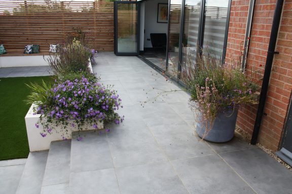 Grey porcelain pato with planting and bifold doors