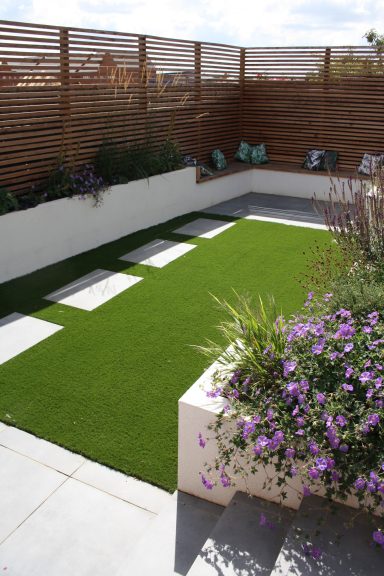 A garden featuring planting, stepping stones and artificial grass
