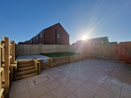 A porcelain patio featuring raised area with lawn