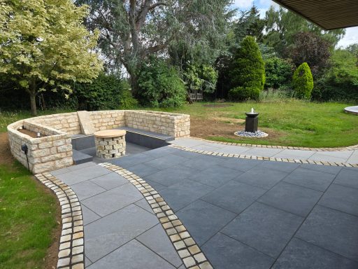A patio seating area with grey porcelain paving and natural stone cobbles